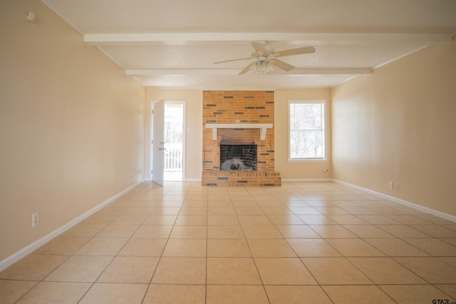 unfurnished living room with a brick fireplace, ceiling fan, beamed ceiling, and light tile patterned flooring