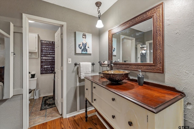 bathroom featuring vanity, wood-type flooring, and toilet