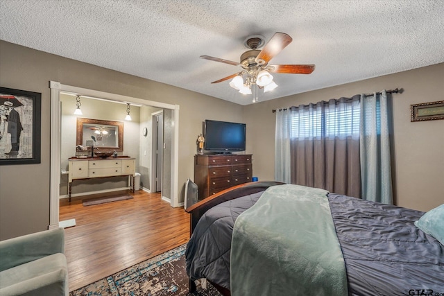 bedroom featuring ceiling fan, wood-type flooring, and a textured ceiling