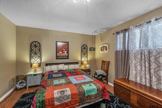 bedroom featuring wood-type flooring and a textured ceiling