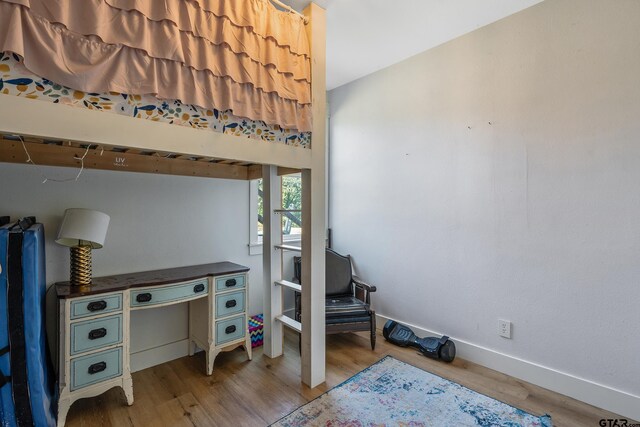 bedroom featuring baseboards and wood finished floors