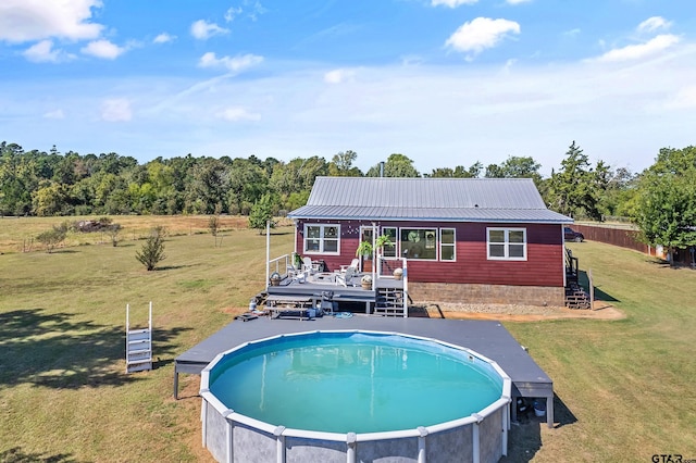 pool with a wooden deck, a lawn, and stairs