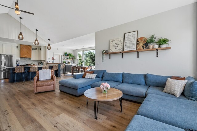 living room featuring a ceiling fan, wood finished floors, and high vaulted ceiling