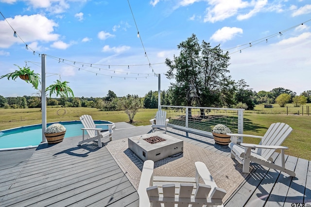 wooden terrace featuring an outdoor pool, a fire pit, and a lawn