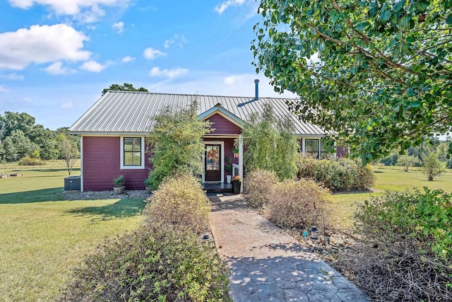 view of front of property featuring a standing seam roof, a front lawn, and metal roof