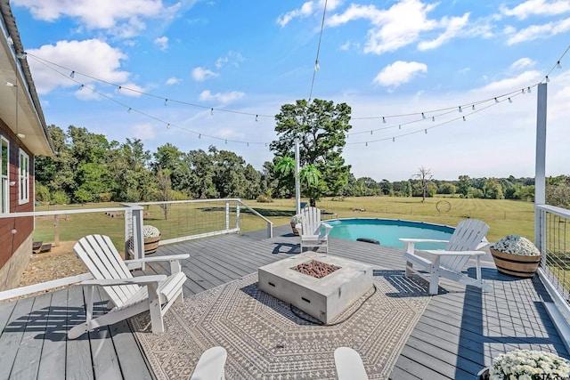 wooden deck featuring a lawn and an outdoor fire pit