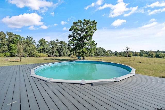 pool featuring a wooden deck and a lawn