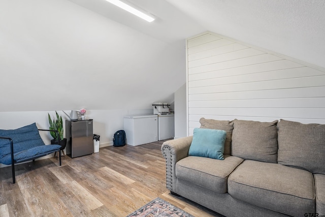 interior space with vaulted ceiling, baseboards, and light wood finished floors