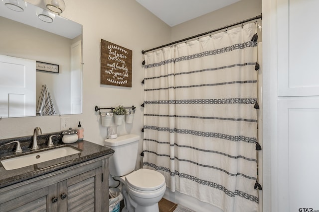 bathroom featuring a shower with shower curtain, toilet, and vanity