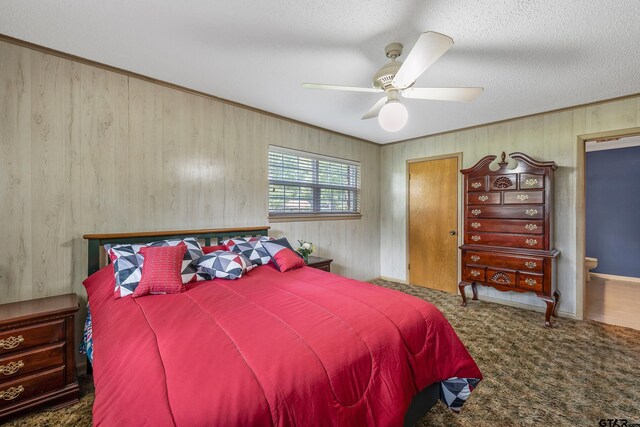110 Leisure Ln, Whitehouse, TX 75791 - bedroom featuring ceiling fan, connected bathroom, a textured ceiling, carpet floors, and wooden walls