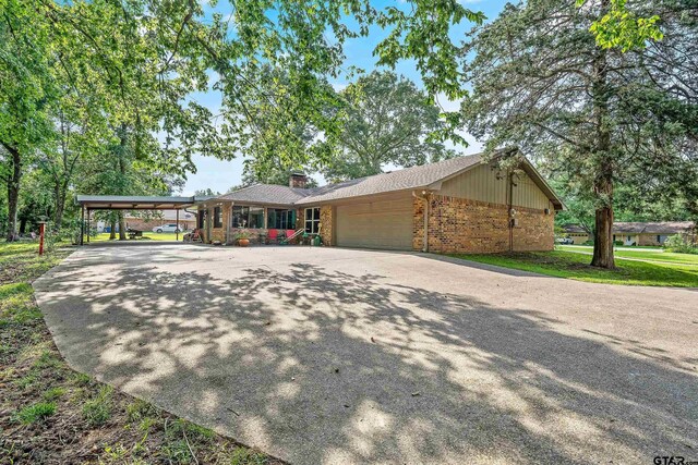 110 Leisure Ln, Whitehouse, TX 75791 - ranch-style home featuring a carport, brick siding, an attached garage, a chimney, and concrete driveway