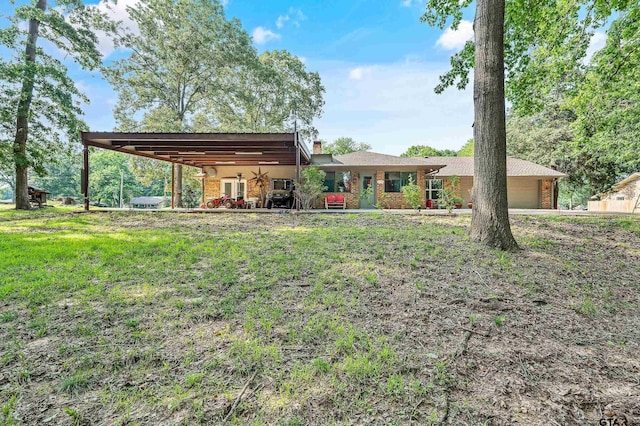 110 Leisure Ln, Whitehouse, TX 75791 - view of front facade with a carport, a front yard, brick siding, a chimney, and a garage