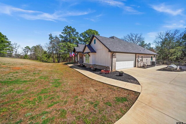 15920 Shepards Gln, Lindale, TX 75771 - view of side of home with central AC, a yard, concrete driveway, a garage, and brick siding