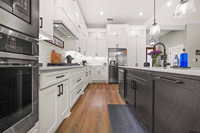 15920 Shepards Gln, Lindale, TX 75771 - kitchen with decorative light fixtures, white cabinets, stainless steel appliances, and wood finished floors