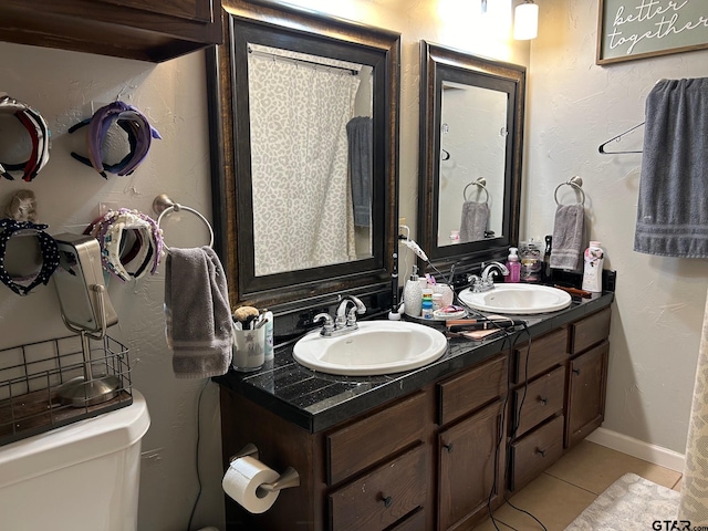 bathroom with vanity, tile patterned flooring, and toilet