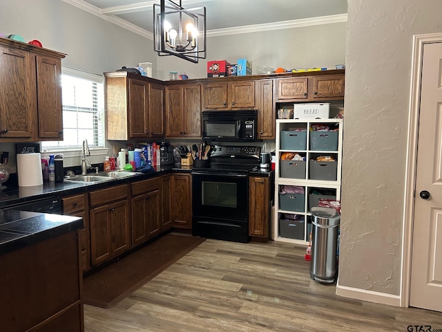 kitchen with wood-type flooring, an inviting chandelier, black appliances, sink, and ornamental molding