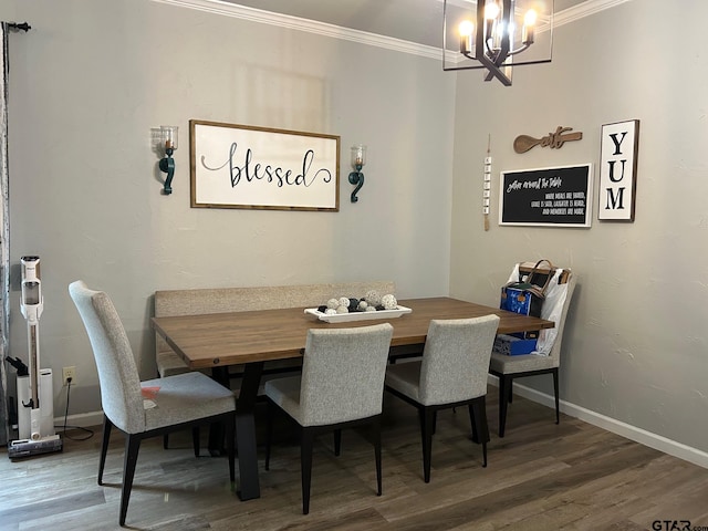 dining room with hardwood / wood-style flooring, a chandelier, and crown molding