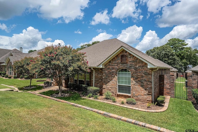 665 Bunker Dr, Tyler, TX 75703 - view of front of home with a front yard, brick siding, roof with shingles, and a gate