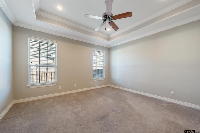 unfurnished room with ornamental molding, light colored carpet, a raised ceiling, and ceiling fan