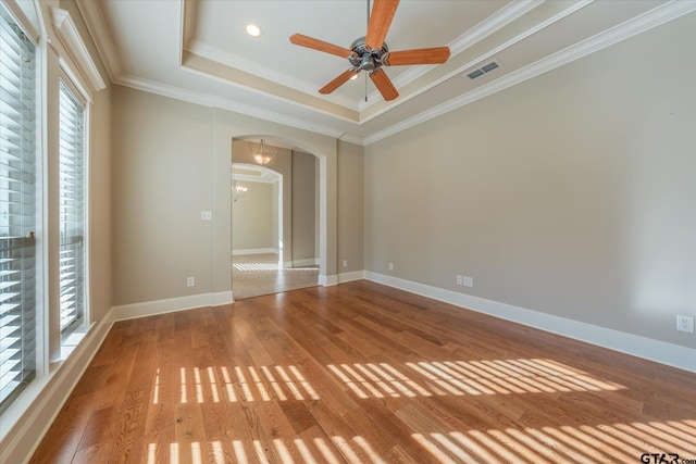 665 Bunker Dr, Tyler, TX 75703 - empty room featuring arched walkways, a raised ceiling, wood finished floors, a ceiling fan, and crown molding