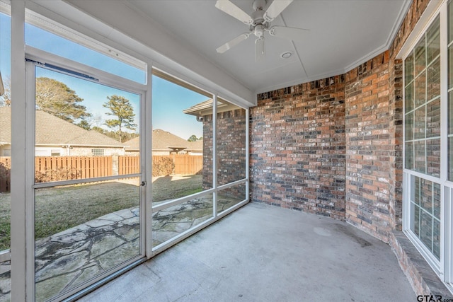 unfurnished sunroom with ceiling fan