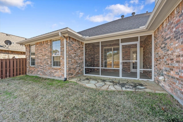 rear view of house with a sunroom and a lawn