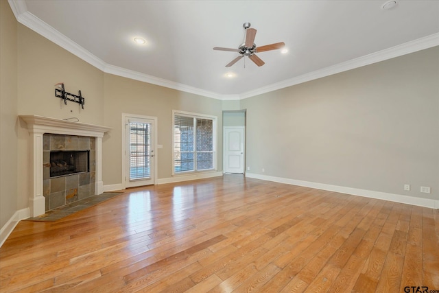 unfurnished living room with a tile fireplace, light wood-type flooring, ceiling fan, and ornamental molding