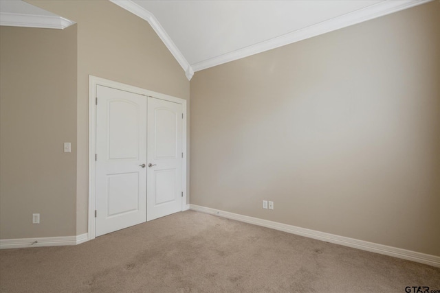 unfurnished bedroom with light colored carpet, vaulted ceiling, and crown molding