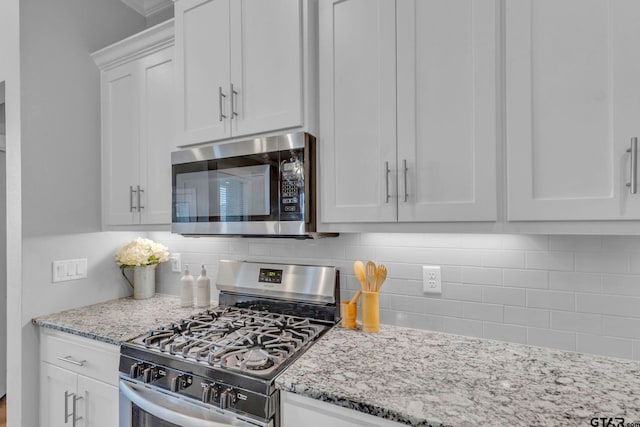 19175 Seneca Dr, Flint, TX 75762 - kitchen with appliances with stainless steel finishes, backsplash, white cabinets, and light stone countertops