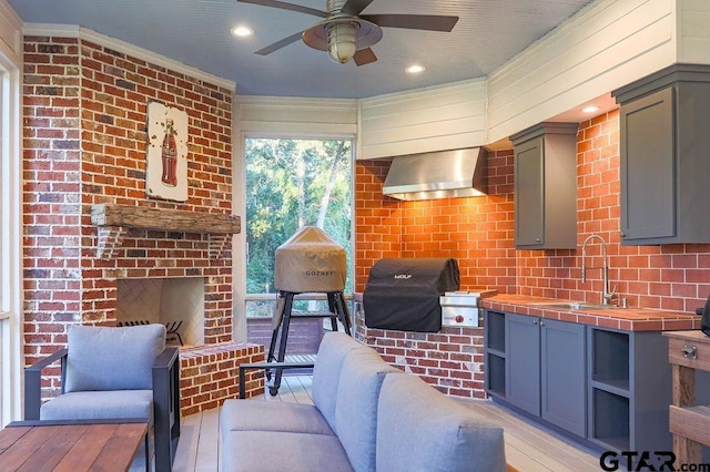 view of patio / terrace featuring an outdoor brick fireplace, a ceiling fan, an outdoor bar, a grill, and a sink