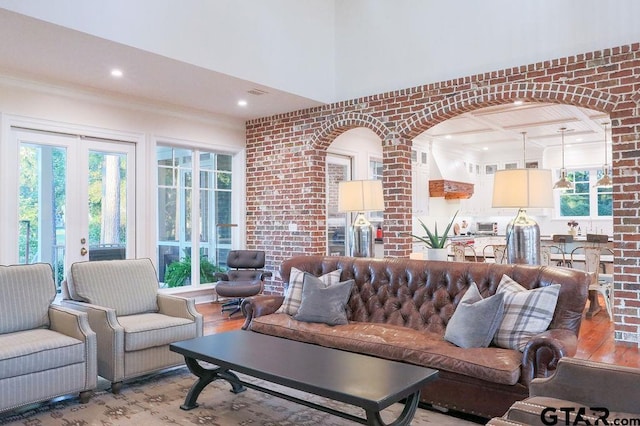 living room featuring brick wall, french doors, light wood-type flooring, and recessed lighting