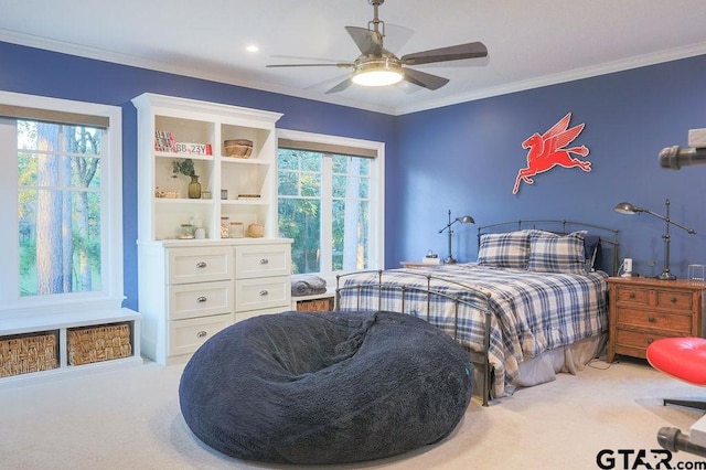 carpeted bedroom with ornamental molding and ceiling fan