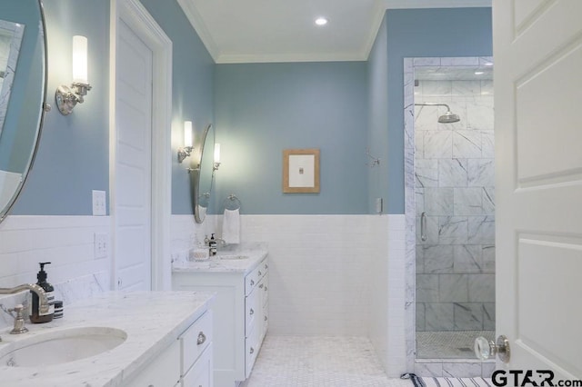 full bathroom with two vanities, crown molding, a shower stall, and a sink