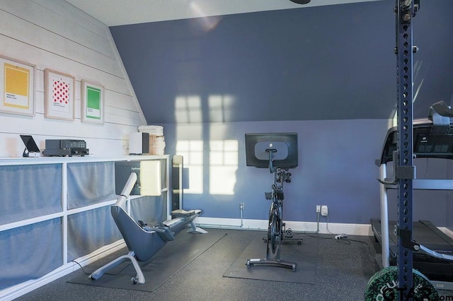 workout area with lofted ceiling and baseboards