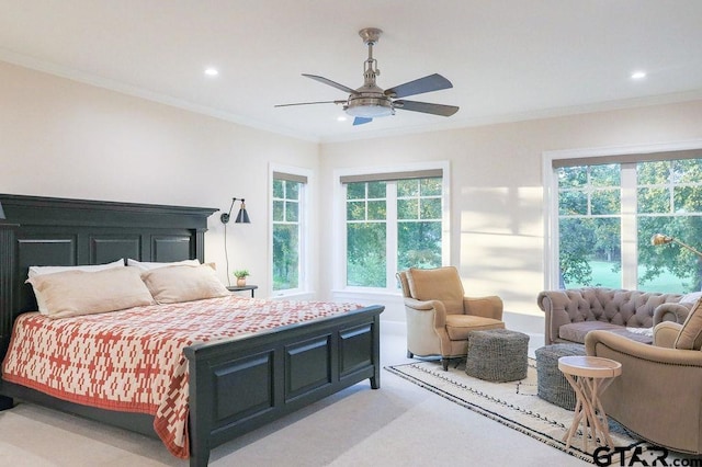 bedroom with ornamental molding, multiple windows, and light colored carpet