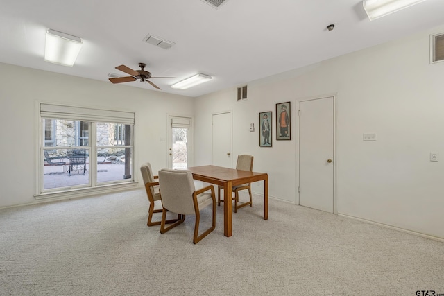 dining space with a ceiling fan, visible vents, and light colored carpet