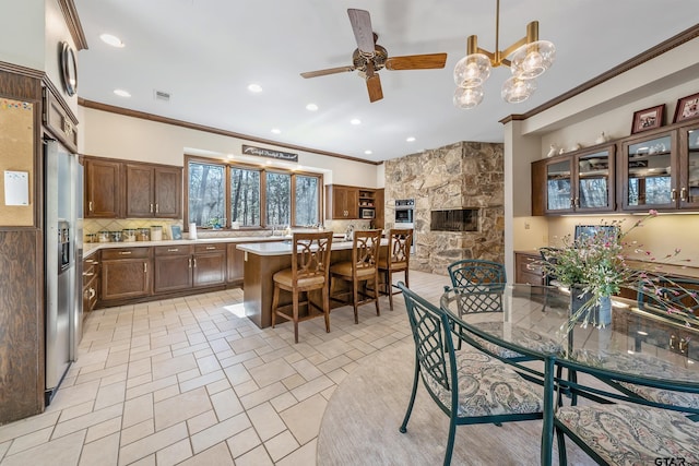 dining area with recessed lighting, visible vents, ornamental molding, a ceiling fan, and a stone fireplace