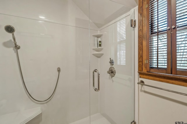 bathroom with a shower stall and vaulted ceiling