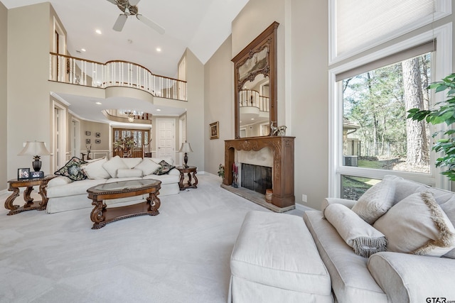 carpeted living area with a fireplace, recessed lighting, ceiling fan, high vaulted ceiling, and baseboards