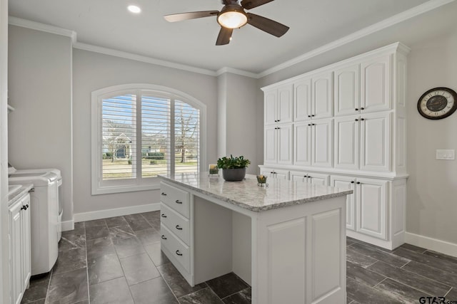 kitchen with white cabinetry, light stone counters, washing machine and dryer, and a center island