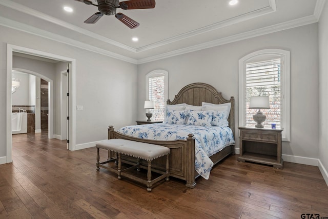 bedroom with dark wood-type flooring, ornamental molding, a tray ceiling, and ceiling fan