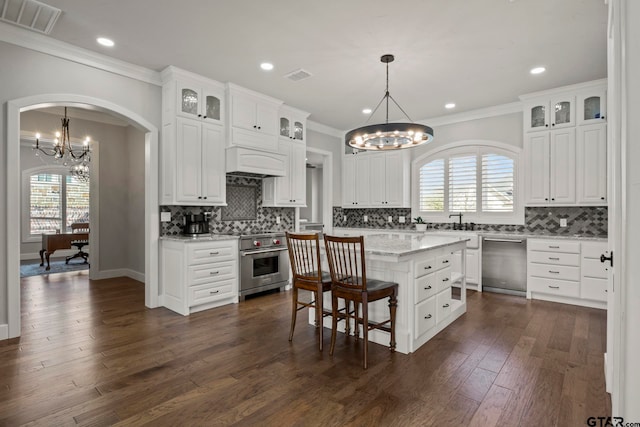 kitchen featuring a kitchen island, white cabinetry, appliances with stainless steel finishes, pendant lighting, and dark wood-type flooring