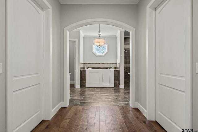 hallway with dark hardwood / wood-style flooring, a notable chandelier, and crown molding