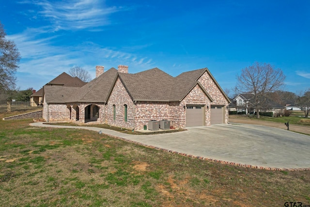 view of front of house with a front lawn, a garage, and cooling unit