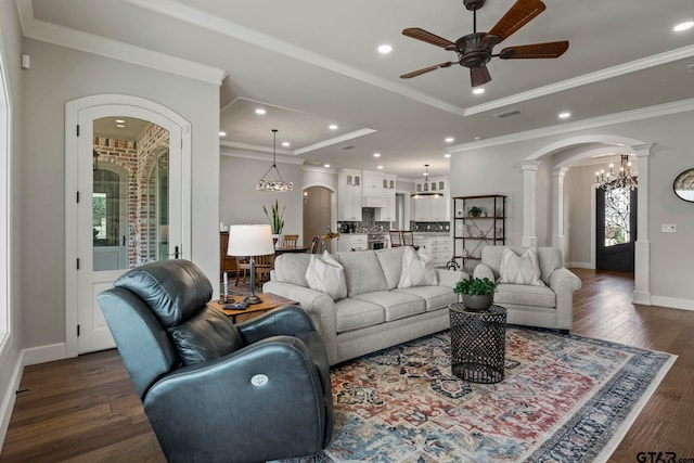 living room featuring ornamental molding, dark hardwood / wood-style floors, ceiling fan, and decorative columns