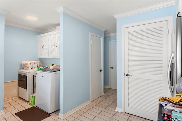 clothes washing area with ornamental molding, cabinets, and light tile patterned floors