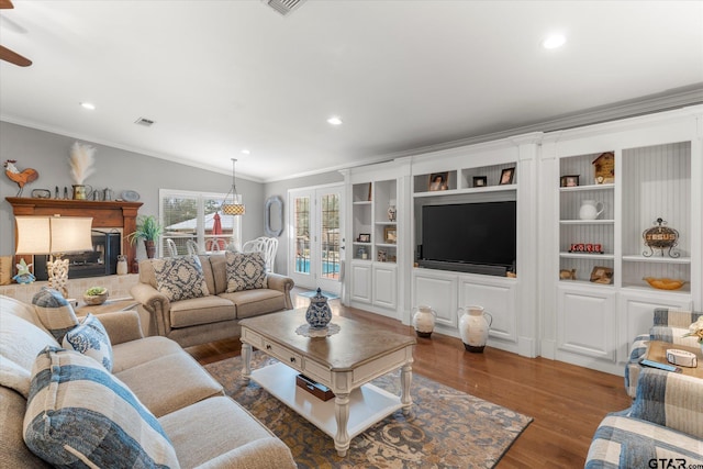 living room with vaulted ceiling, dark hardwood / wood-style flooring, ornamental molding, and a fireplace