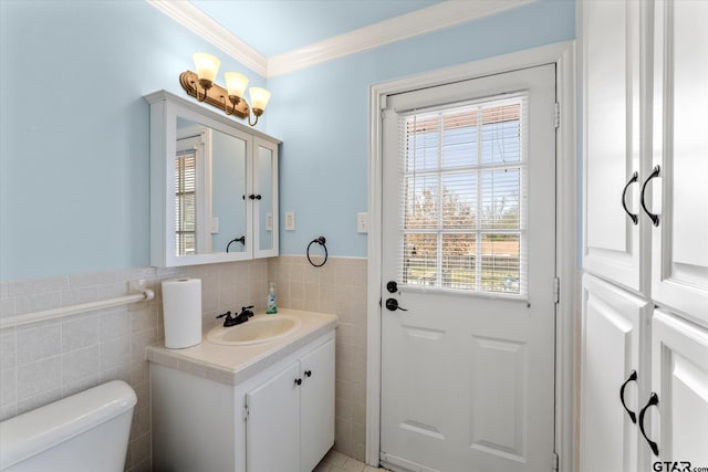 bathroom featuring toilet, crown molding, tile walls, and vanity