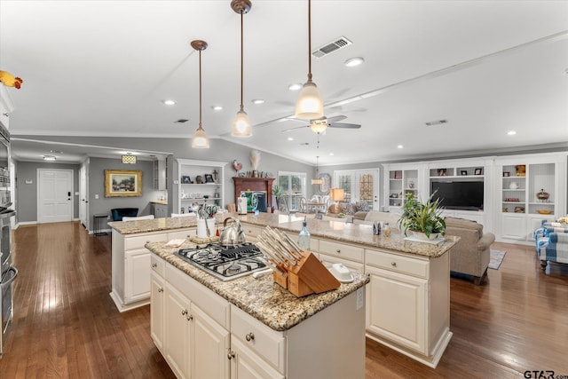 kitchen with hanging light fixtures, a center island, lofted ceiling, and light stone counters