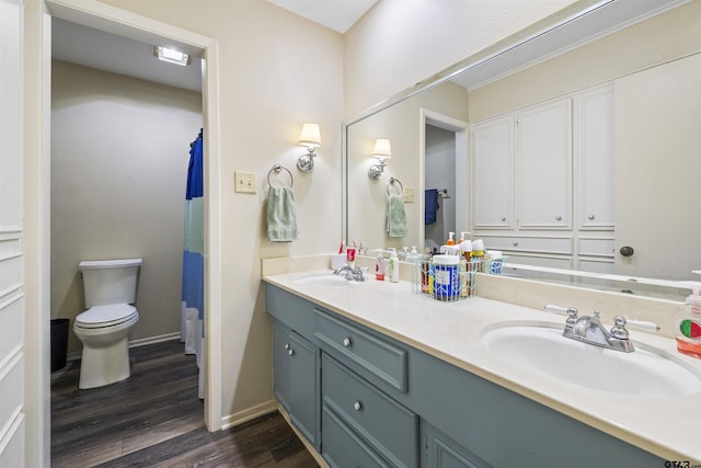 1723 Kensington Dr, Tyler, TX 75703 - full bathroom with wood finished floors, toilet, double vanity, baseboards, and curtained shower